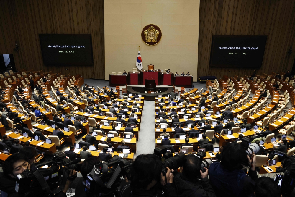 Lawmakers arrive for the plenary session of the impeachment vote of South Korea's President Yoon Suk Yeol at the National Assembly in Seoul December 7, 2024. — Jeon Heon-kyun/Pool/AFP pic