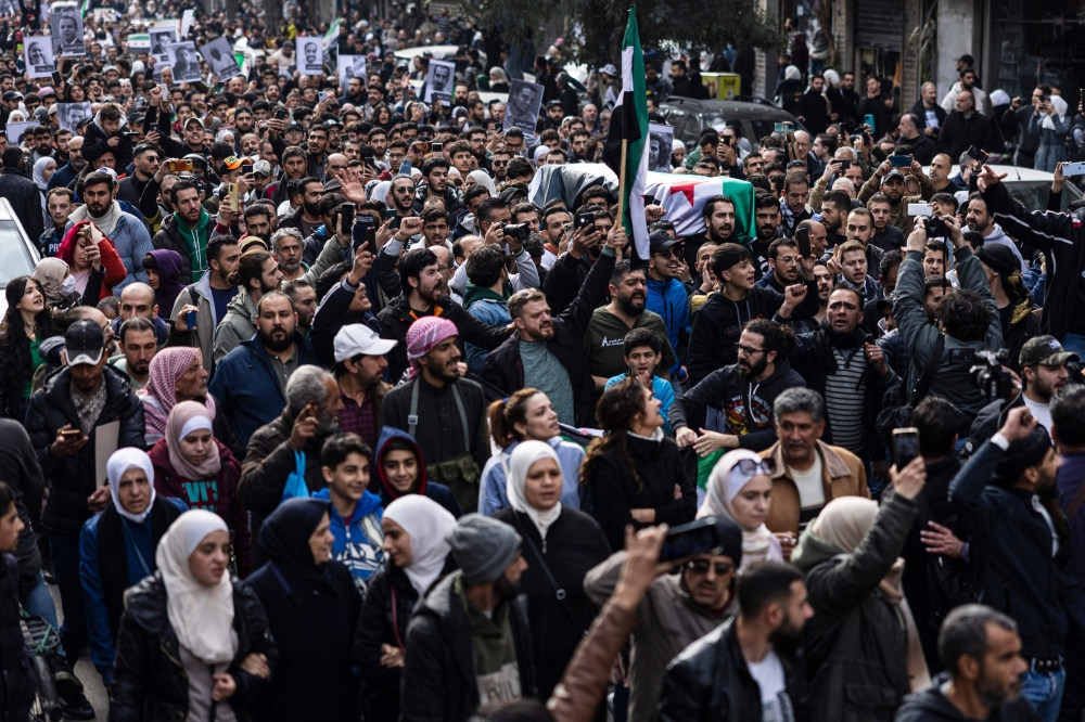 Mourners attend the funeral of Syrian activist Mazen al-Hamada, whose body was found recently, in the capital Damascus on December 12, 2024. — AFP pic