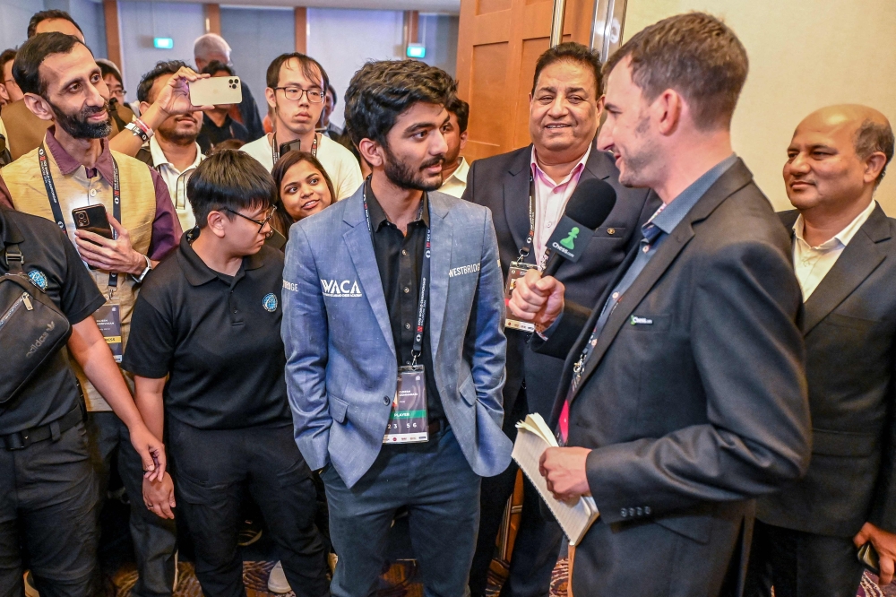 India's grandmaster Gukesh Dommaraju (centre) speaks with a media personnel after winning against China's chess grandmaster Ding Liren in game 14 of the 2024 FIDE World Championship in Singapore on December 12, 2024. — AFP pic