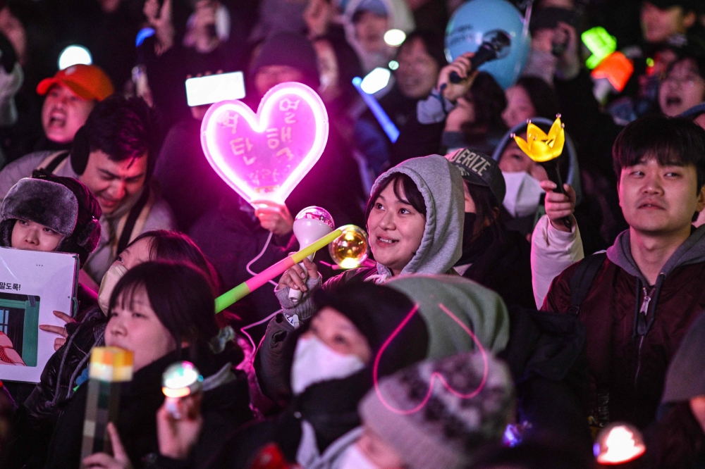 Protesters calling for the ouster of South Korea President Yoon Suk Yeol react after the result of the second martial law impeachment vote outside the National Assembly in Seoul on December 14, 2024. South Korean lawmakers on December 14 voted to remove President Yoon Suk Yeol from office for his failed attempt to impose martial law last week. — AFP pic