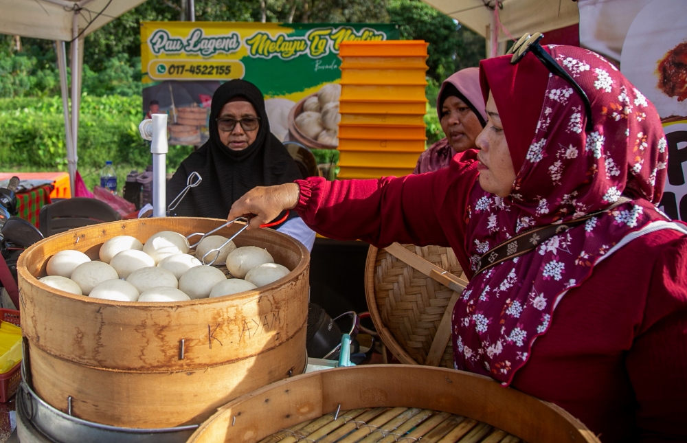 Visitors select Kuih Pau at a stall during the Pau Festival X Muallim Recreation 2024 event at the Bernam River waterfront in Tanjung Malim December 15, 2024. — Bernama pic