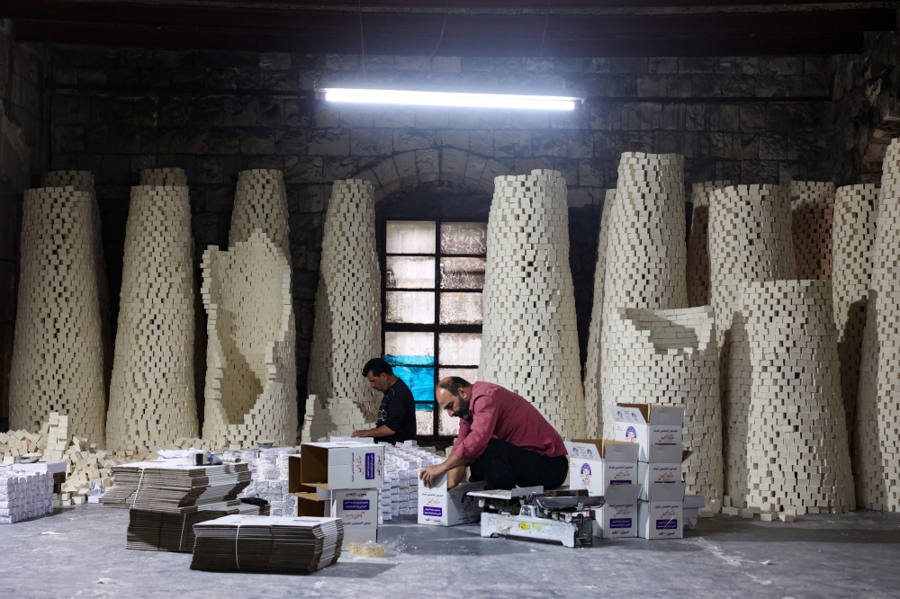 Workers pack bars of soap at a local soap factory in the the old city of Nablus, in the occupied West Bank November 28, 2024. — AFP pic