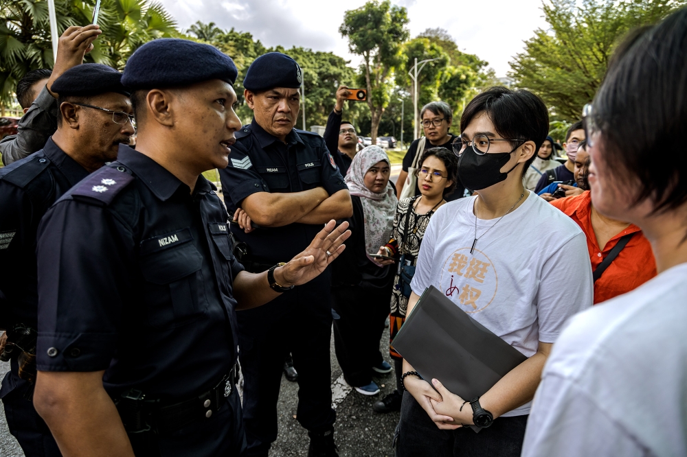 Police officers speak to attendees demonstrating against sexual harassment at Universiti Malaya in Kuala Lumpur on Dec 20, 2024. — Picture by Firdaus Latif