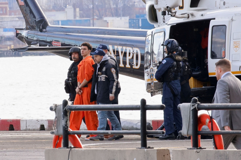 Luigi Mangione, the suspect in the murder of UnitedHealth Group executive Brian Thompson, arrives at a helicopter pad after being extradited from Pennsylvania, in New York December 19, 2024. — Reuters pic  