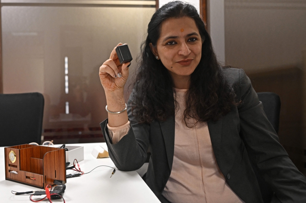 In this photograph taken on December 7, 2024, Akriti Khatri, founder of Venus Detective Agency, shows a GPS tracker and an audio bug device during an interview with AFP in New Delhi. — AFP pic