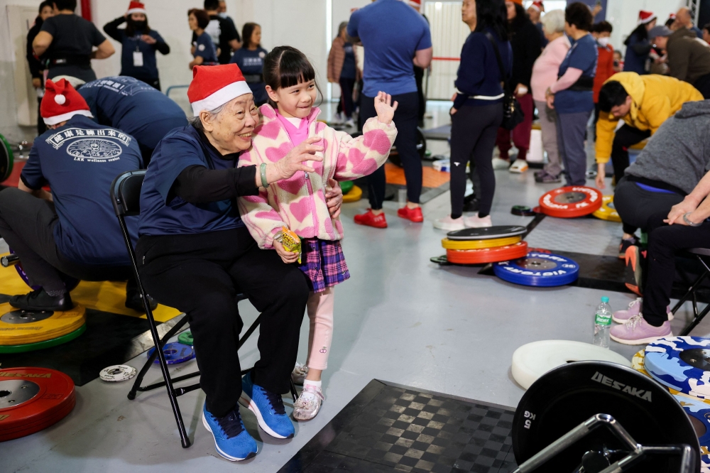 Cheng Chen Chin-Mei with her great-granddaughter at the weightlifting competition. — Reuters pic