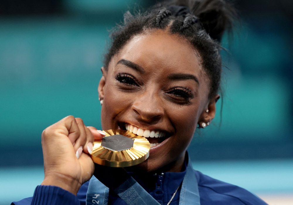 Gold medallist Simone Biles of United States celebrates on the podium after winning the Artistic Gymnastics Women's All-Around category at the Bercy Arena, Paris August 1, 2024. — Reuters pic  