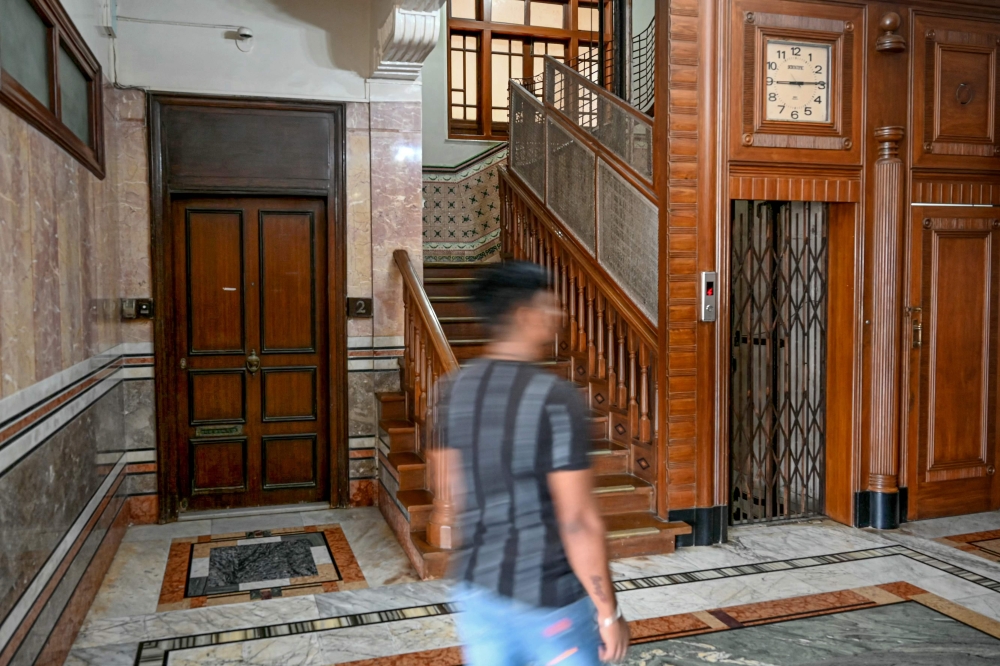 In this photograph taken on October 19, 2024, a man walks past the lobby area of the Seksaria building, a Unesco-designated Art Deco apartment along the Marine Drive seafront in Mumbai. — AFP pic