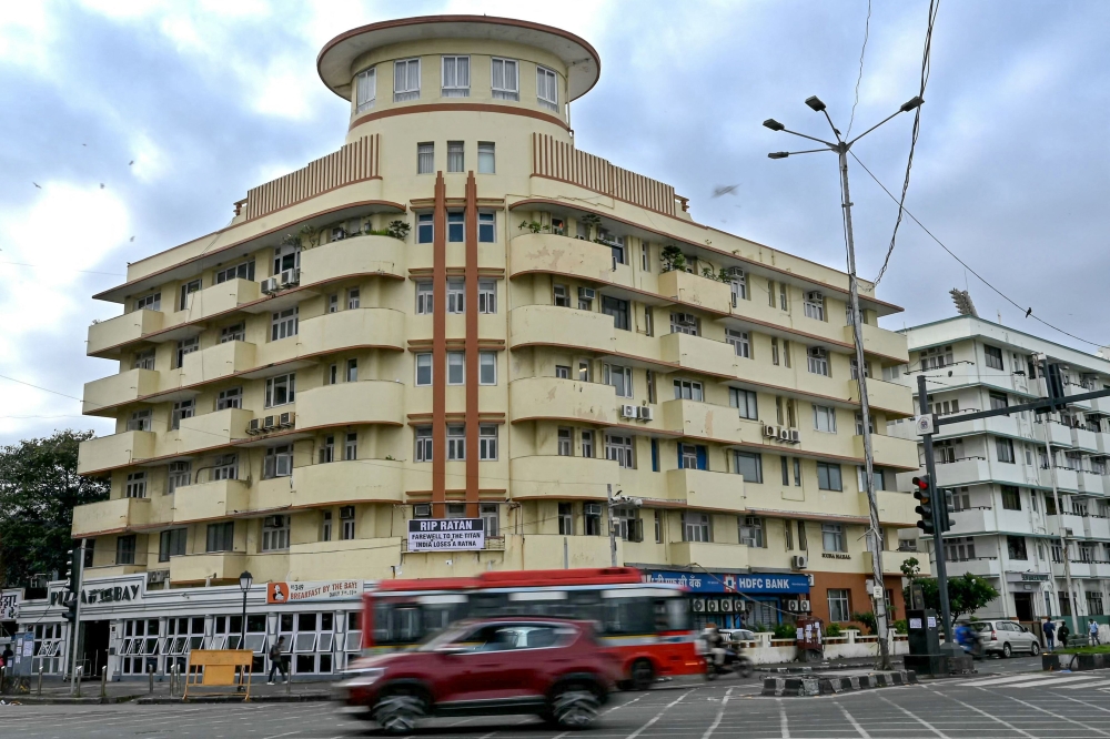 In this photograph taken on October 19, 2024, vehicles ride past the Soona Mahal, a Unesco-designated Art Deco apartment building along the Marine Drive seafront in Mumbai. — AFP