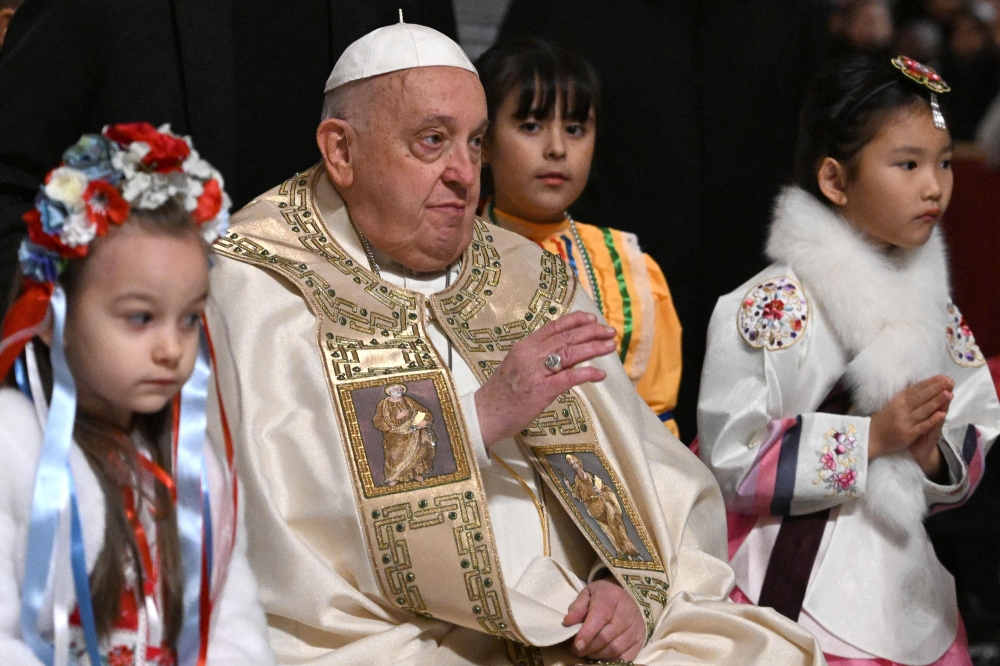 Pope Francis is surrounded by children at the end of the Christmas Eve mass at The St Peter's Basilica in the Vatican on December 24, 2024. — AFP pic