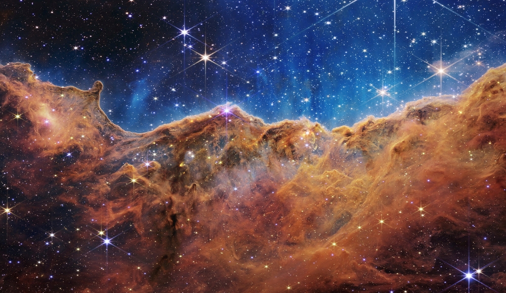 The ‘Cosmic Cliffs’ of the Carina Nebula are seen in an image divided horizontally by an undulating line between a cloudscape forming a nebula along the bottom portion and a comparatively clear upper portion. — Nasa, ESA, CSA, STScI, Webb ERO Production Team/Handout via Reuters