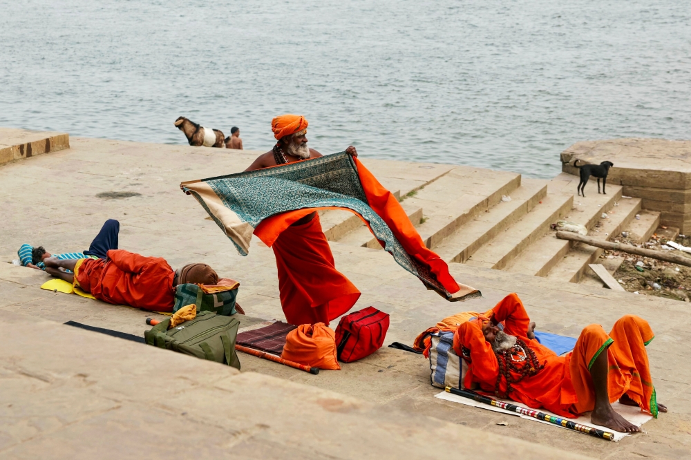 Sadhus or Hindu holy men rest along the banks of river Ganges, at Narad Ghat in Varanasi on December 23, 2024. — AFP pic