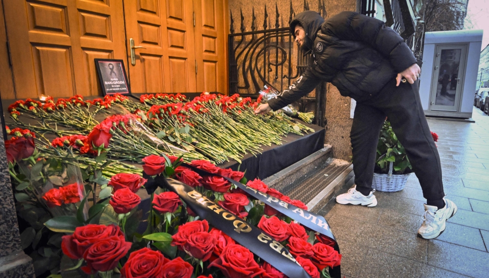 A man lays flowers to Azerbaijan’s Embassy in Moscow paying tribute to the victims of Azerbaijan Airlines’ plane crash. — AFP