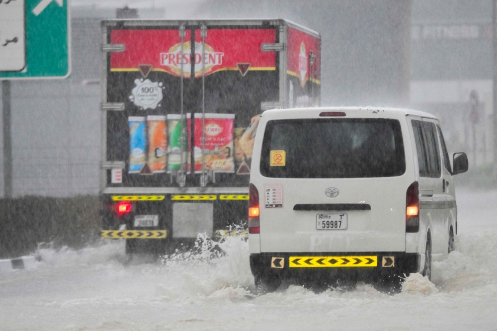 Vehicles drive on a flooded road during torrential rain in the Gulf Emirate of Dubai on April 16, 2024. — AFP pic