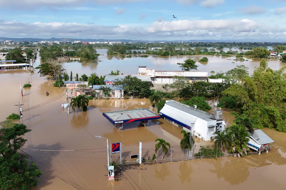 This aerial photo shows buildings submerged in floodwaters due to a swollen river caused by heavy rains from Super Typhoon Man-yi in Tuguegarao City, Cagayan province November 19, 2024. — AFP pic