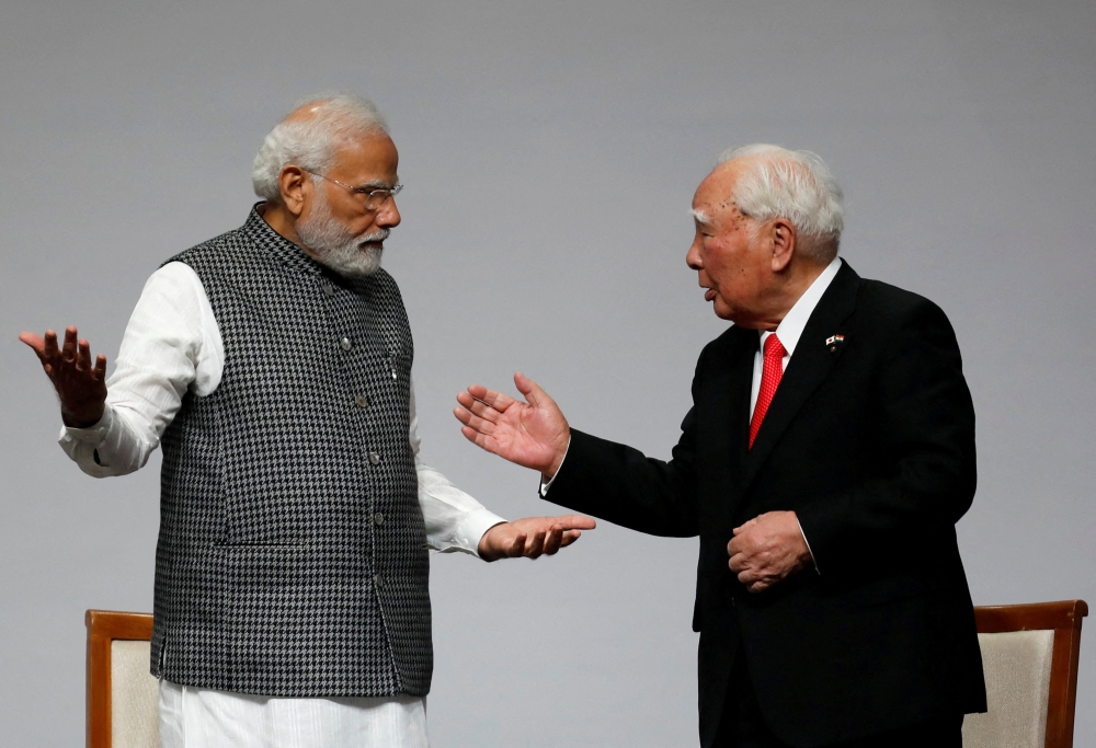 India’s Prime Minister Narendra Modi speaks with Japan’s Suzuki Motor Corp former chairman Osamu Suzuki during an event to commemorate 40 years of Suzuki in India, in Gandhinagar, August 28, 2022. — Reuters pic