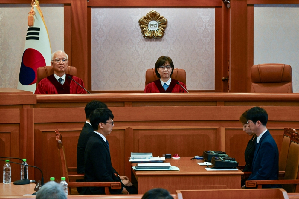 South Korean Constitutional Court's Judge Lee Mi-son and Cheong Hyung-sik sit in during the first preparatory hearing of a trial on the validity of President Yoon Suk Yeol's impeachment by the National Assembly at the constitutional court of Korea in Seoul December 27, 2024. — Song Kyung-Seok/Kyodo/Pool pic via Reuters  