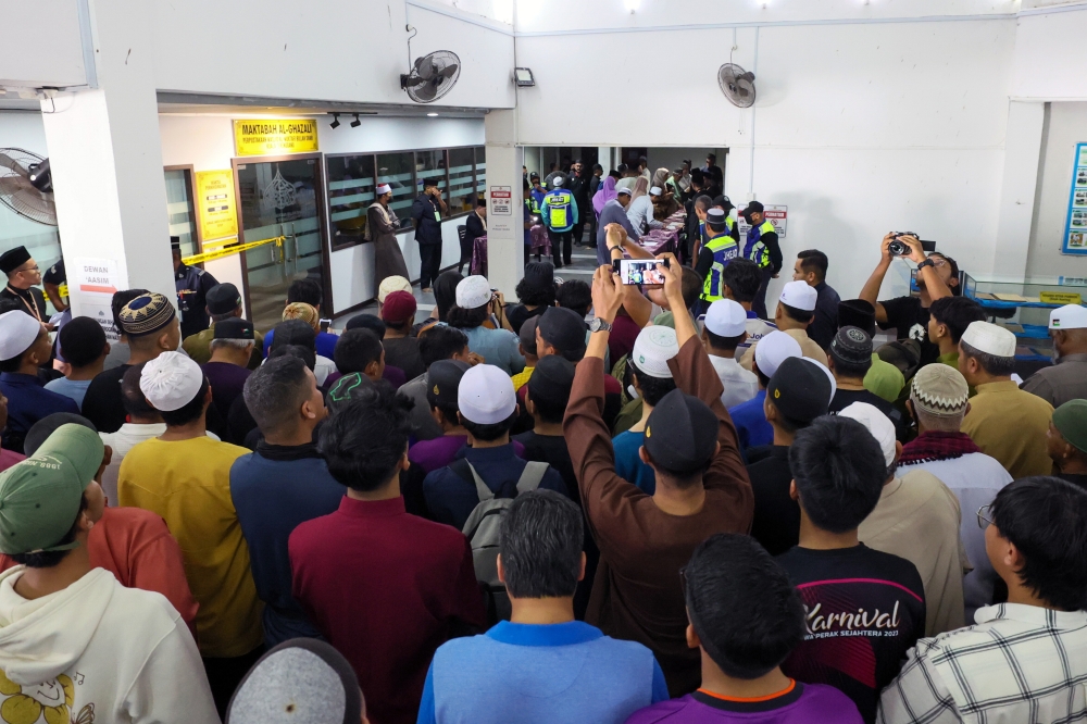 Members of the public attempting to catch a glimpse of the public caning punishment against a 42-year-old man convicted of repeated “khalwat”, or close proximity with the opposite sex in Kuala Terengganu. — Bernama pic