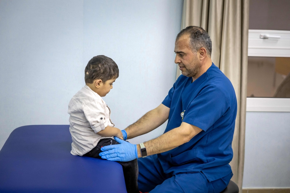 A doctor treats a Palestinian child injured in the Gaza Strip during the war between Israel and Hamas, at a hospital in Abu Dhabi December 12, 2024. — AFP pic