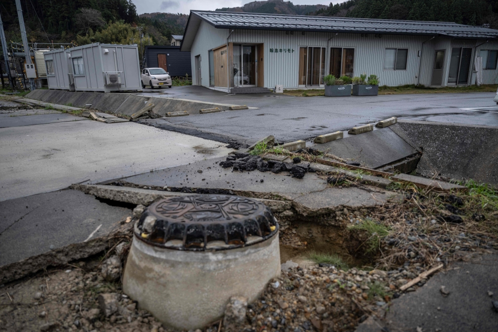 A general view of a damaged sidewalk in front of the Wajima Kirimoto lacquerware studio in Wajima city, Ishikawa prefecture, December 11, 2024. — AFP pic