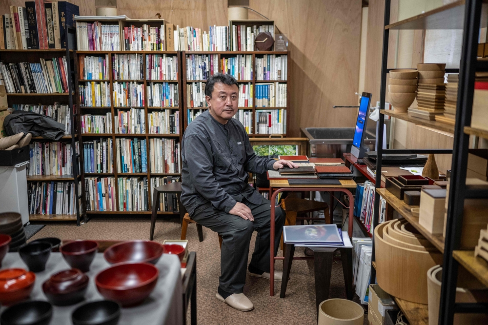 Taiichi Kirimoto, the seventh-generation proprietor of a Wajima-nuri lacquerware studio, poses for photographs in his studio in Wajima city, Ishikawa prefecture December 11, 2024. — AFP pic