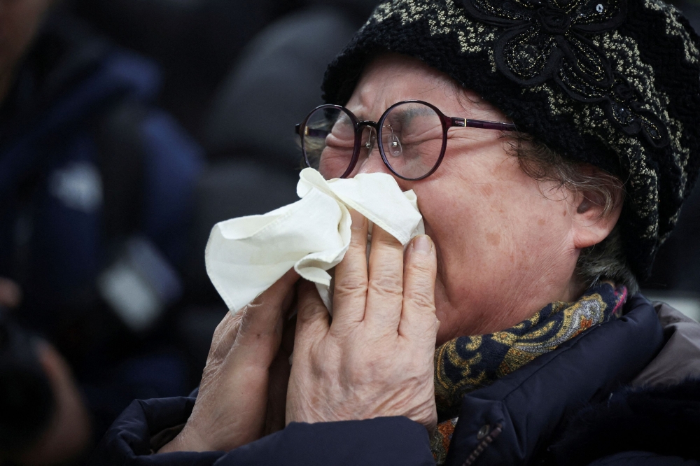 A relative of a passenger of the aircraft that crashed after it went off the runway, reacts at Muan International Airport, in Muan, South Korea, December 29, 2024. — Reuters pic