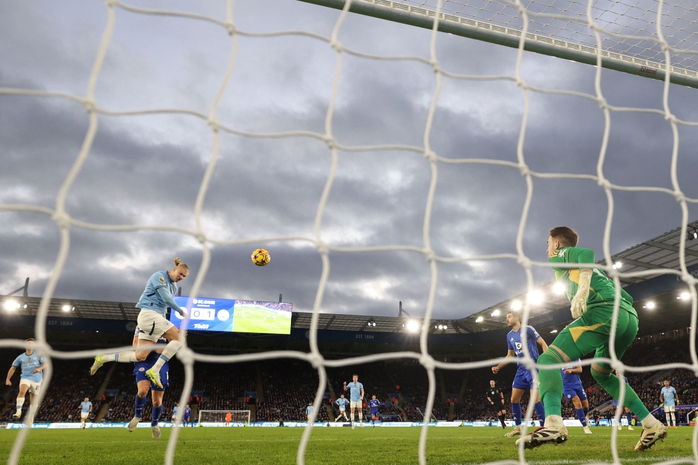 Manchester City’s Erling Haaland (2L) heads home their second goal. — AFP