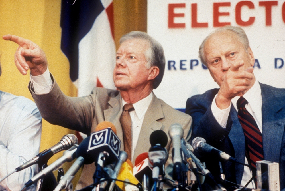 Former US Presidents Jimmy Carter and Gerald Ford point in different directions while calling on reporters wanting to ask questions at a press conference in Panama City, Panama, May 5, 1989. — Reuters pic