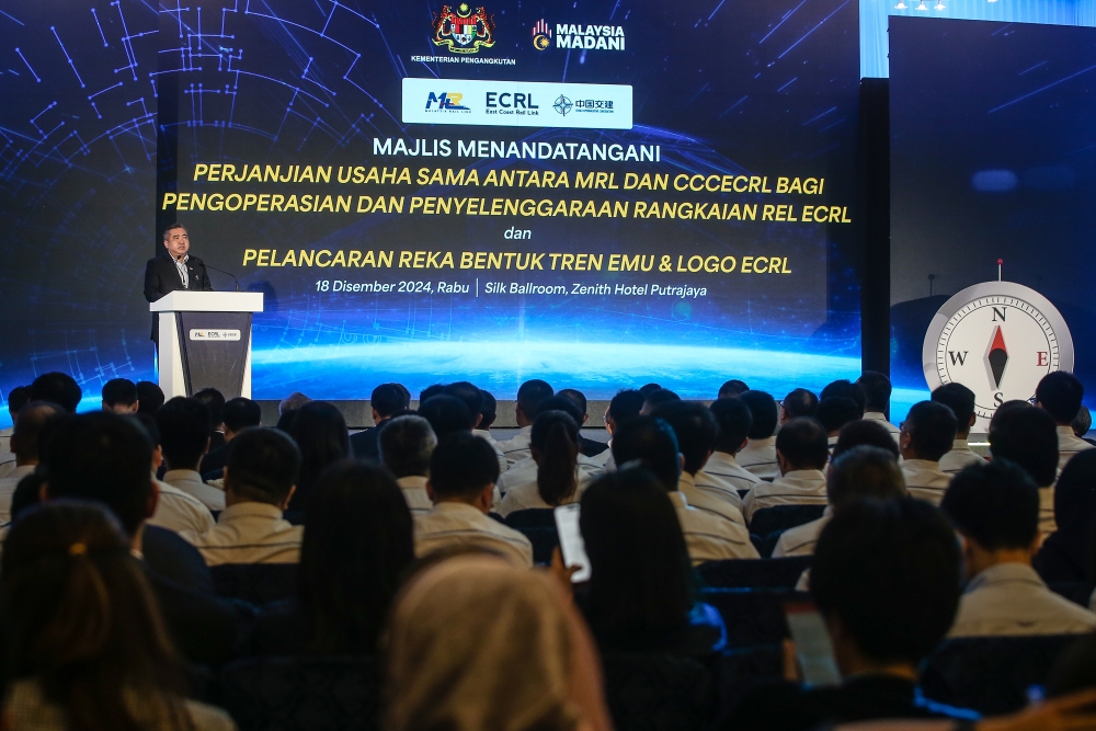 Transport Minister Anthony Loke delivers his speech during the ECRL operation agreement signing ceremony and the launch of the Electric Multiple Unit (EMU) train design and ECRL logo at Zenith Hotel in Putrajaya December 18, 2024. — Picture by Yusof Mat Isa