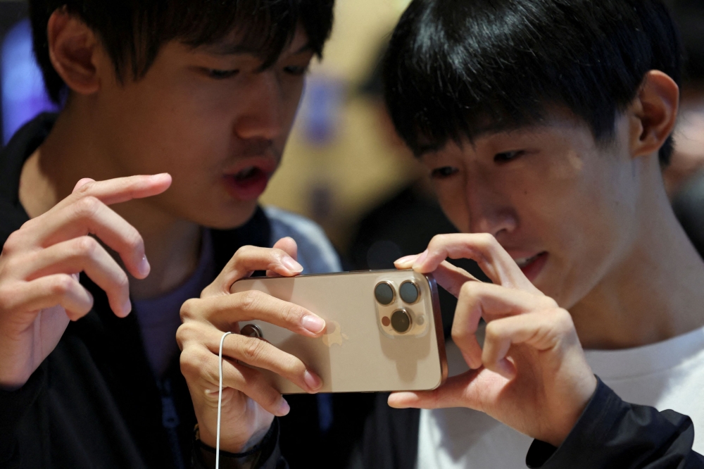 People check an iPhone 16 Pro at an Apple store in Beijing. — Reuters pic