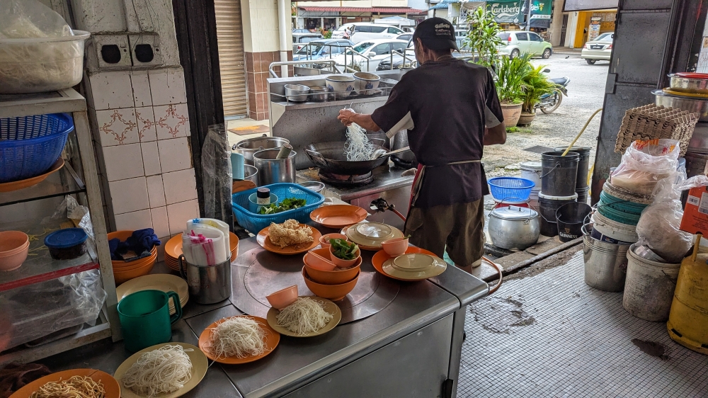 Part of the wait is a result of him frying each order individually. — Picture by Ethan Lau