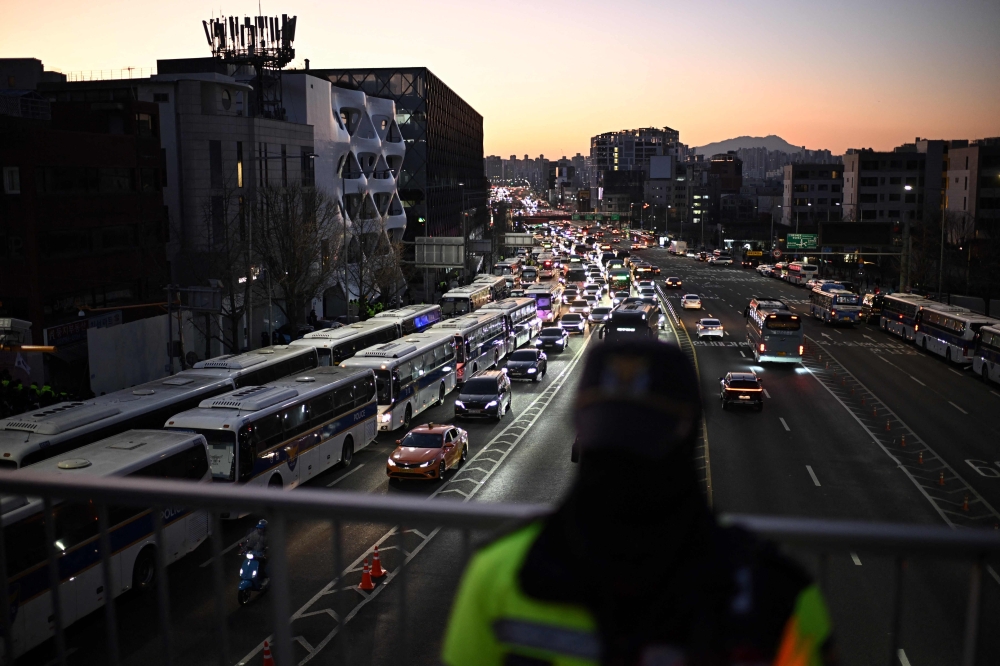 South Korean police vehicles (left) gather near the residence of South Korea's impeached President Yoon Suk-yeol in Seoul January 3, 2025. — AFP pic