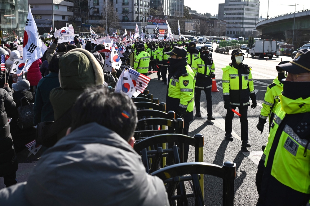 Police keep watch over supporters of South Korea's impeached President Yoon Suk-yeol gathered near his residence in Seoul on January 3, 2025.  — AFP pic