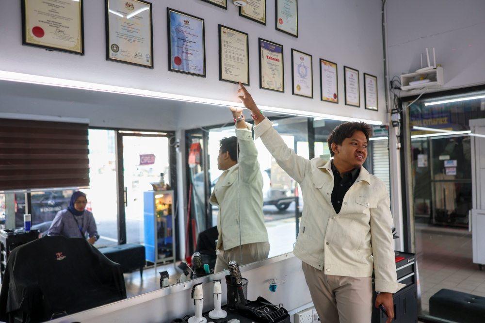 Once operating under a tree, Sallehuddin now owns Takara Barbershop at MARA Arcade, Klang. — Bernama pic