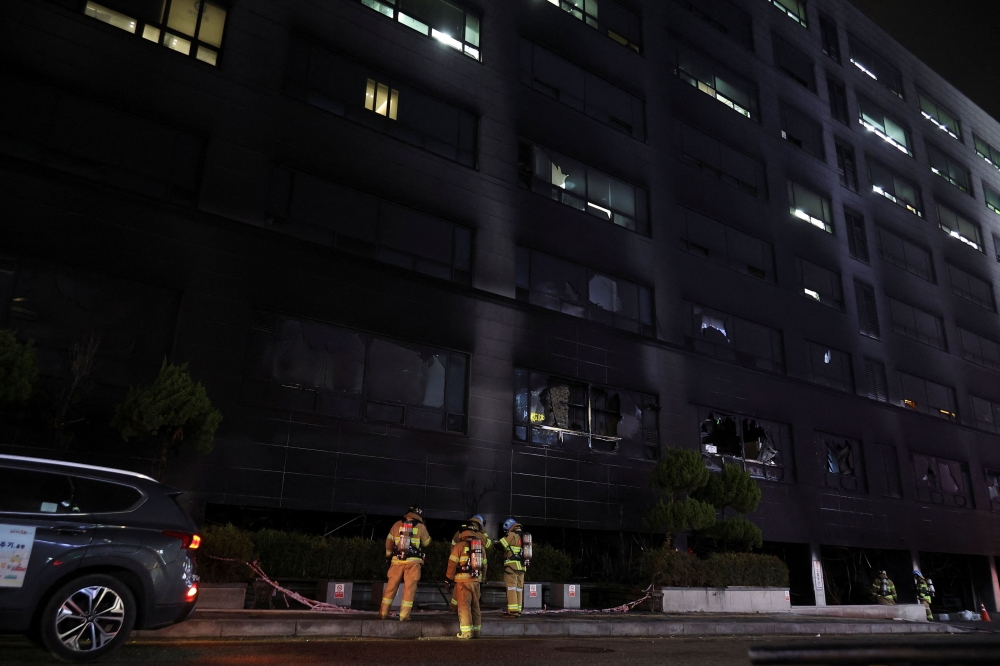 FIre fighters outside the eight-story building in the South Korean city of Seongnam on Friday. — Reuters pic