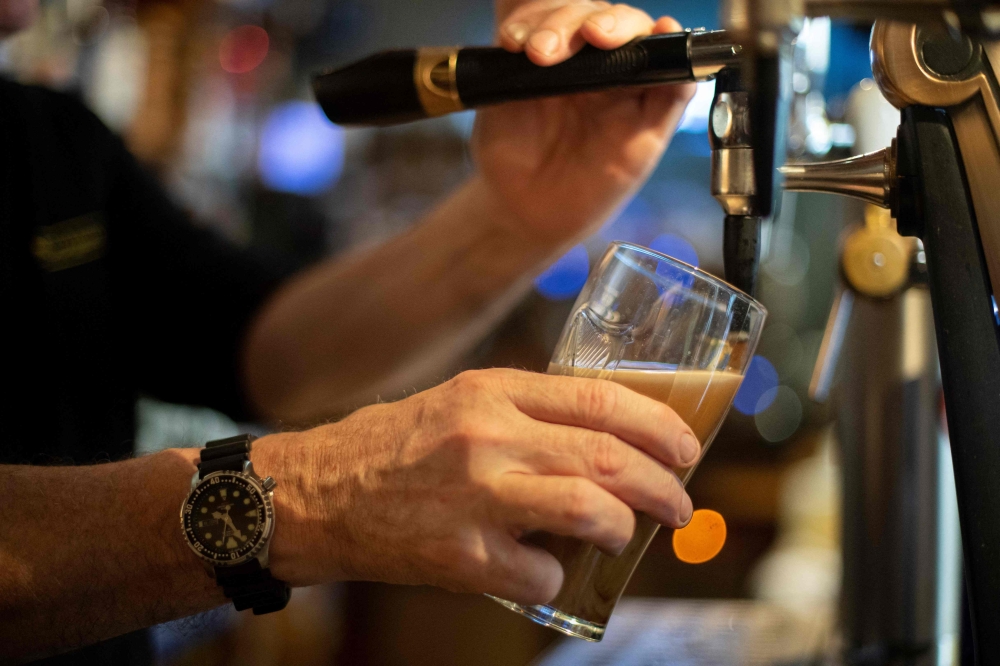 A bartender pours a daft beer in a bar in Brest, western France January 10, 2023. The evidence that alcohol consumption increases the risk of malignancy is strongest for cancers of the breast, colon and rectum, esophagus, liver, mouth, throat, and larynx. — AFP pic