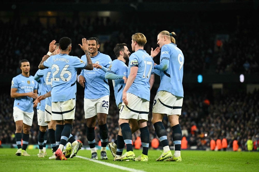 Manchester City’s Erling Haaland (right) celebrates with teammates after scoring his team third goal at the Etihad Stadium.  — AFP