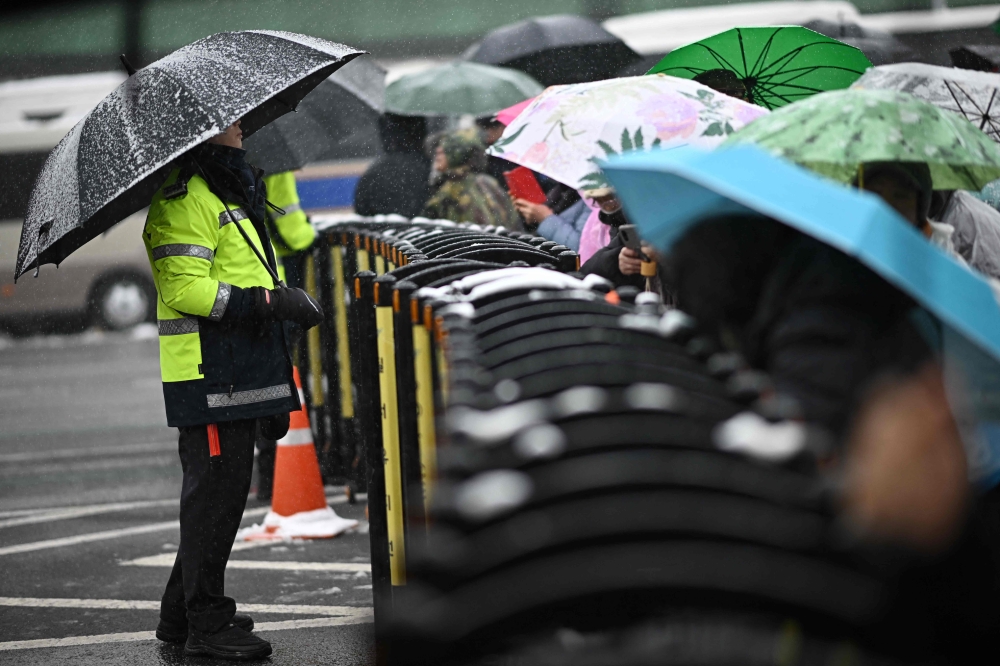 A police officer looks on beside a barrier as supporters of impeached South Korea President Yoon Suk Yeol gather. — AFP