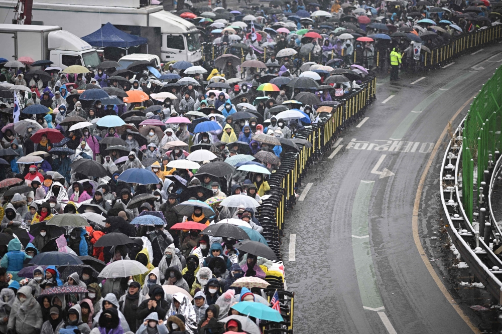 Supporters of impeached South Korea president Yoon Suk Yeol take part in a rally near his residence as snow falls in Seoul on January 5, 2025. Rival South Korean protesters were set to brave a snowstorm January 5 over suspended President Yoon Suk Yeol who was still resisting arrest less than 48 hours before the warrant expires. — AFP pic