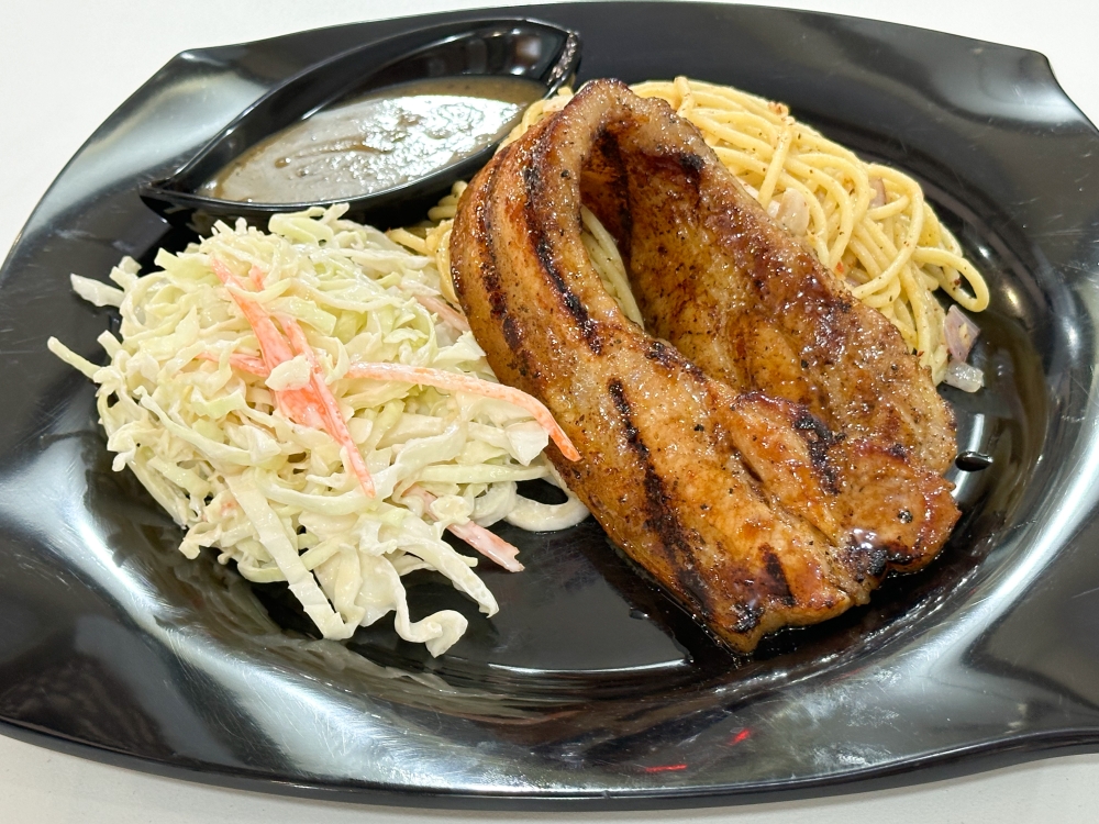 For a juicy and fattier cut, go for the Pork Belly Good served with aglio olio pasta and coleslaw. — Picture by Lee Khang Yi