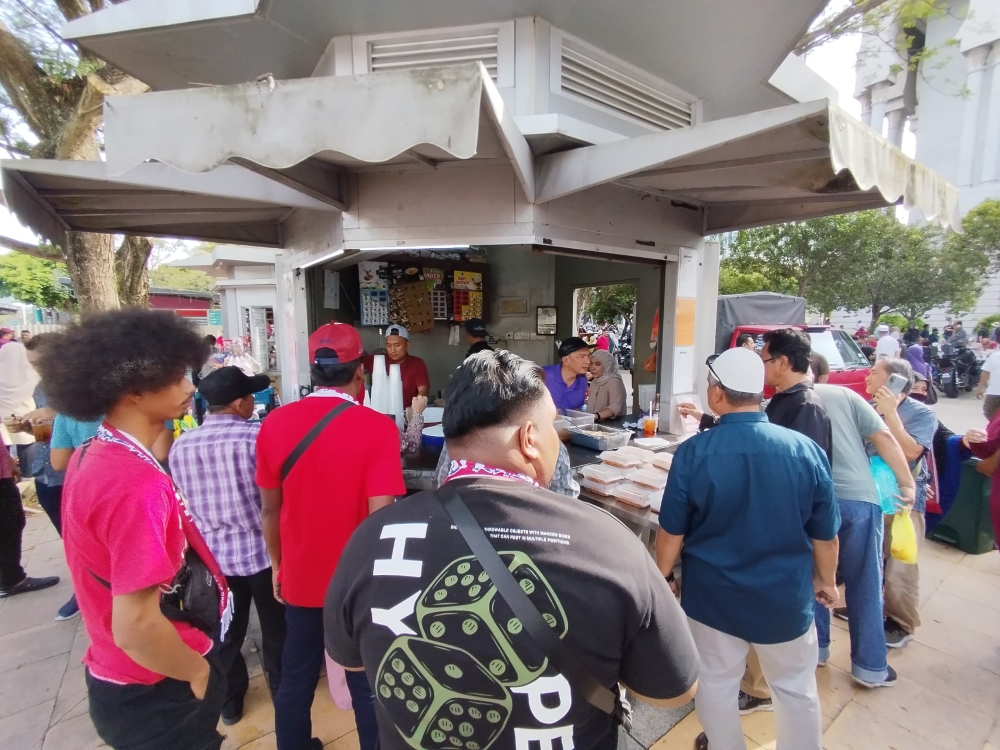 Rally-goers lining up at a food stall outside the Palace of Justice to buy nasi lemak for breakfast before the event in Putrajaya on January 6, 2025. — Picture by Muhammad Yusry