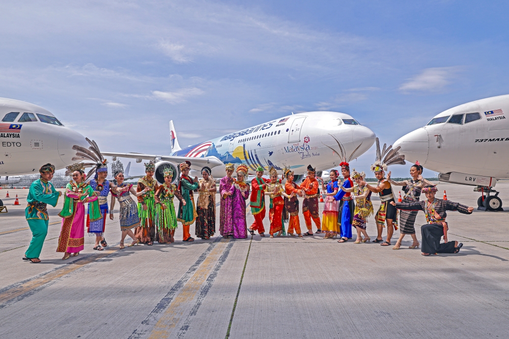 Flight attendants pose with an aircraft featuring the new Visit Malaysia Year 2026 logo during a preview held in conjunction with the Launch Ceremony of the Visit Malaysia Year 2026 Campaign at the MAB Engineering Complex today. — Bernama pic