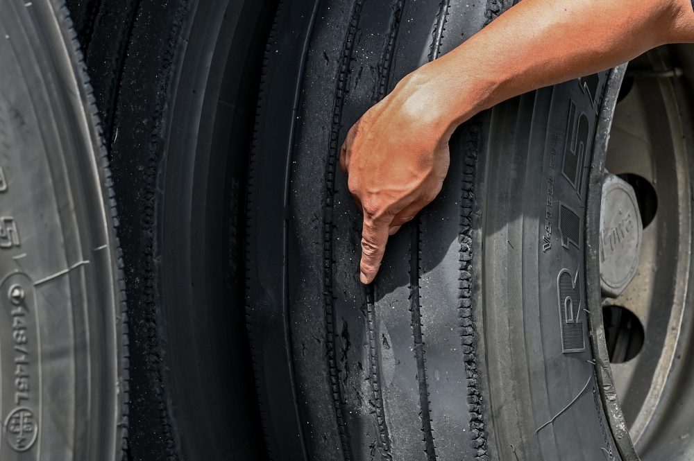 A Road Transport Department officer inspects the condition of a lorry’s tyre during the Ops Gempur Teknikal at the Gemuruh Toll Plaza, Kuala Terengganu. — Bernama pic