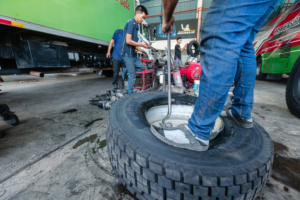 A worker removes a tyre from a rim using a machine at an automotive workshop in Batu Caves. January 6, 2025. — Picture by Raymond Manuel