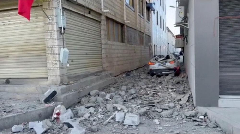 A damaged car lies amidst rubble on the street following an earthquake in Lhatse County, Shigatse City. — Reuters pic/Social Media