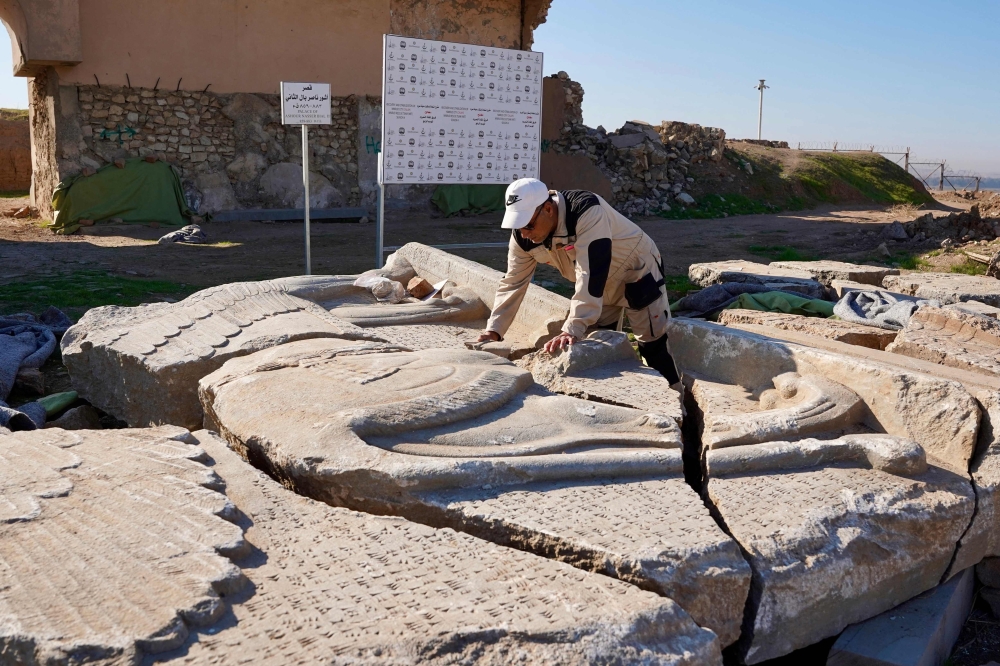 An archaeology expert catalogues destroyed archaeological artefacts at the archaeological site of Nimrud, south of Mosul, on January 3, 2025. — AFP pic