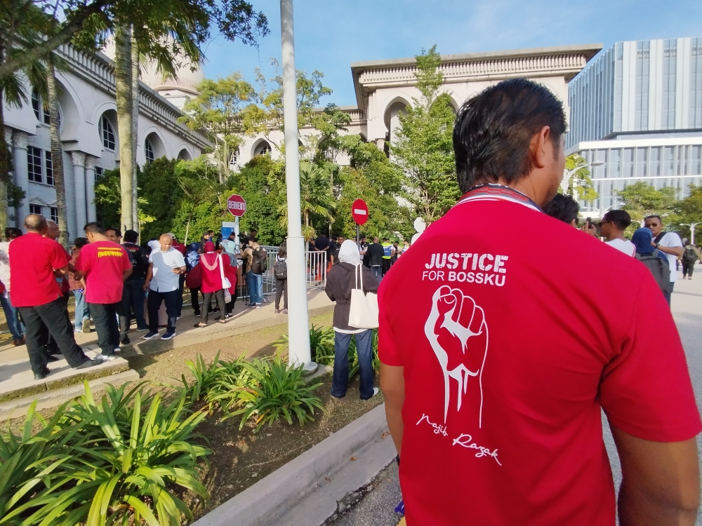 A supporter of Datuk Seri Najib Razak wearing a red shirt with the words ‘Justice for Bossku’ and his name printed on the back. — Picture by Muhammad Yusry