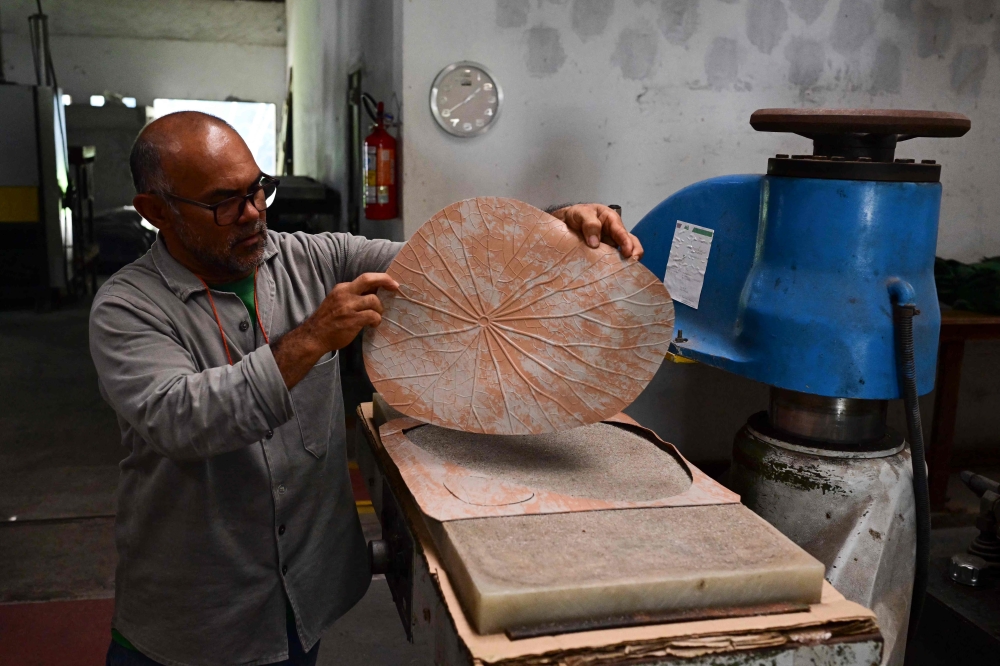 A worker handles processed rubber at the Seringo factory, where all the raw material for the production of rubber footwear is made, near Castanhal city, Para state, Brazil on December 10, 2024. — AFP pic