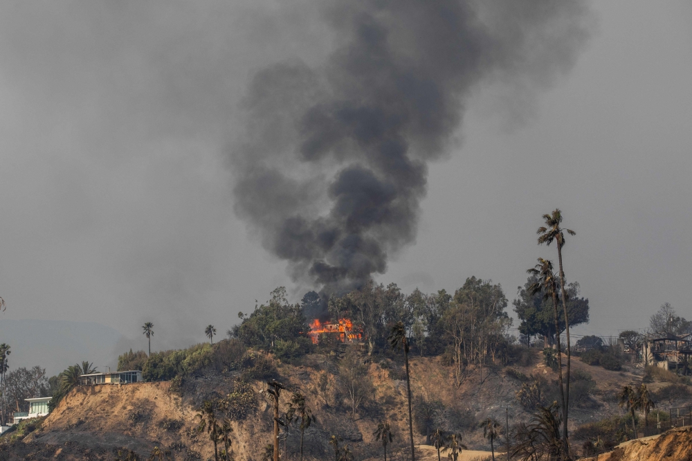 Flames from the Palisades Fire burns a home amid a powerful windstormon January 9, 2025 in the Pacific Palisades neighborhood of Los Angeles. — AFP