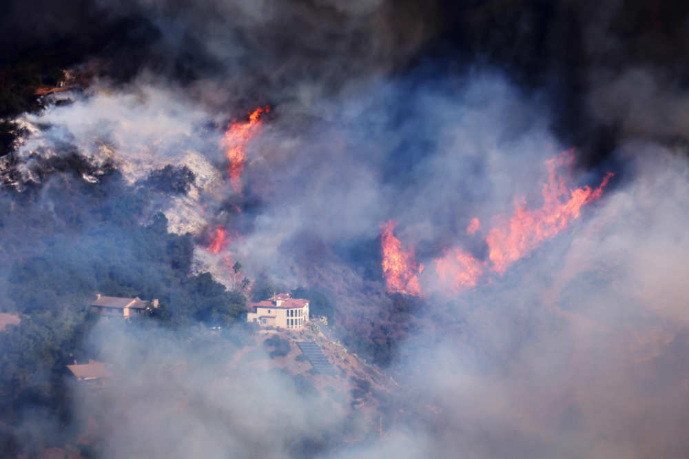 A house is threatened as the Palisades Fire grows in the mountains in the community of Topanga. — AFP